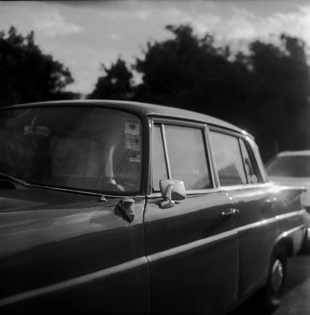 a small old car parked next to the curb