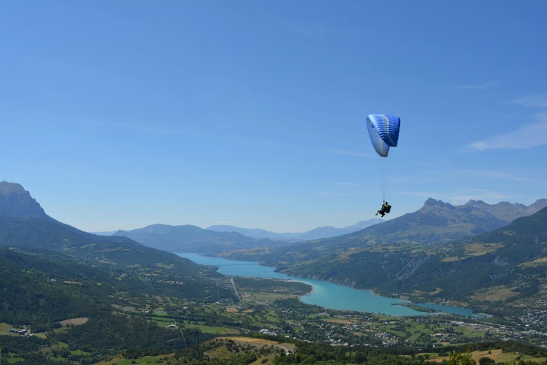 two people on the top of a hill are flying a kite