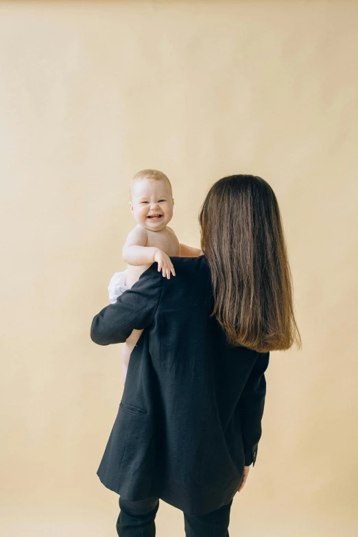 a woman standing up holding a baby