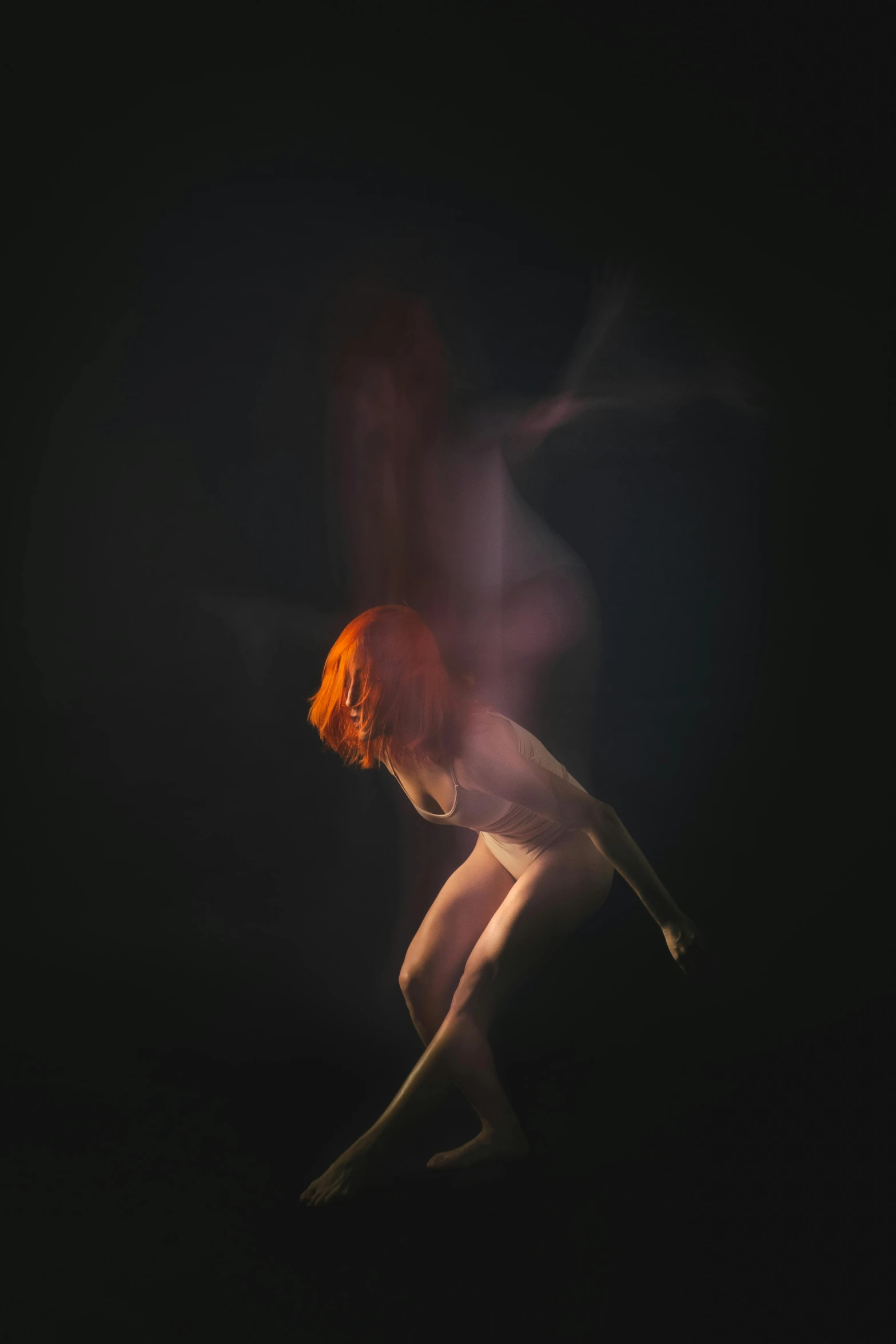 an orange haired girl standing under water with her head under her legs