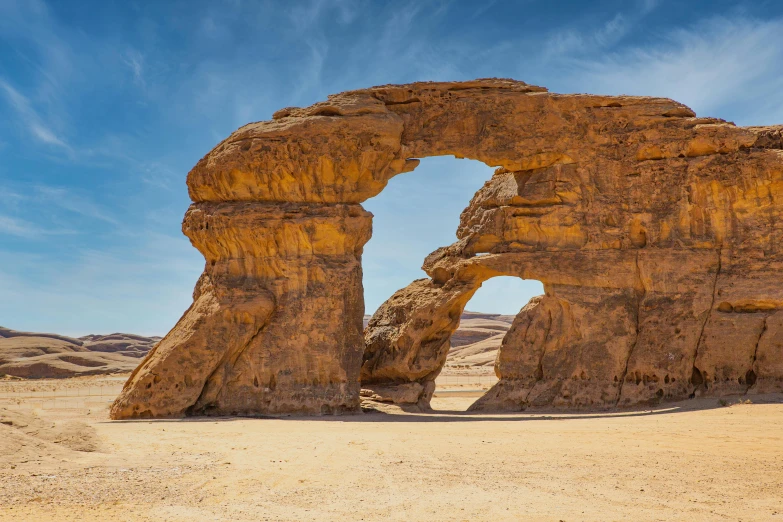 an arch in the sand in the middle of nowhere