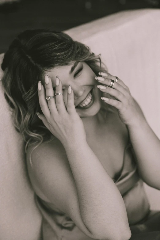 a smiling woman has rings on her face and sits on a couch