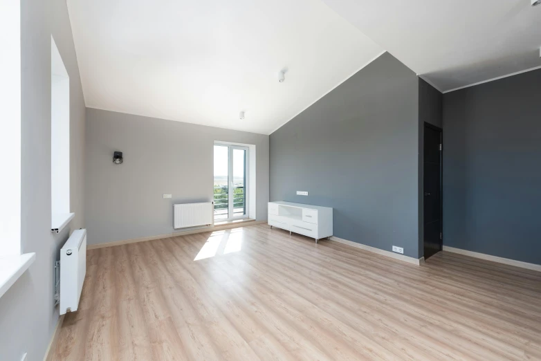 a empty room with hard wood floors and a radiator