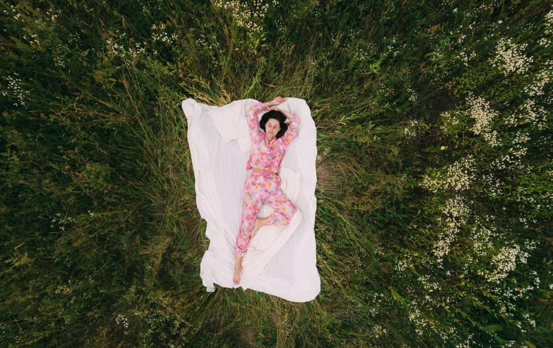 a woman is lying down in the grass