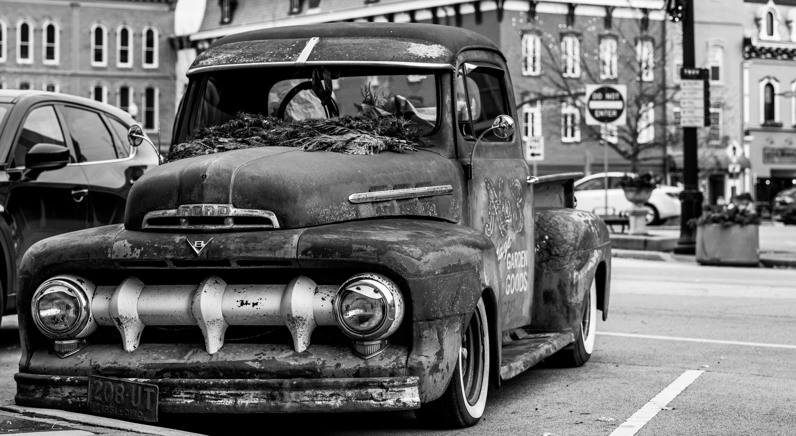 an old truck with flowers in the front