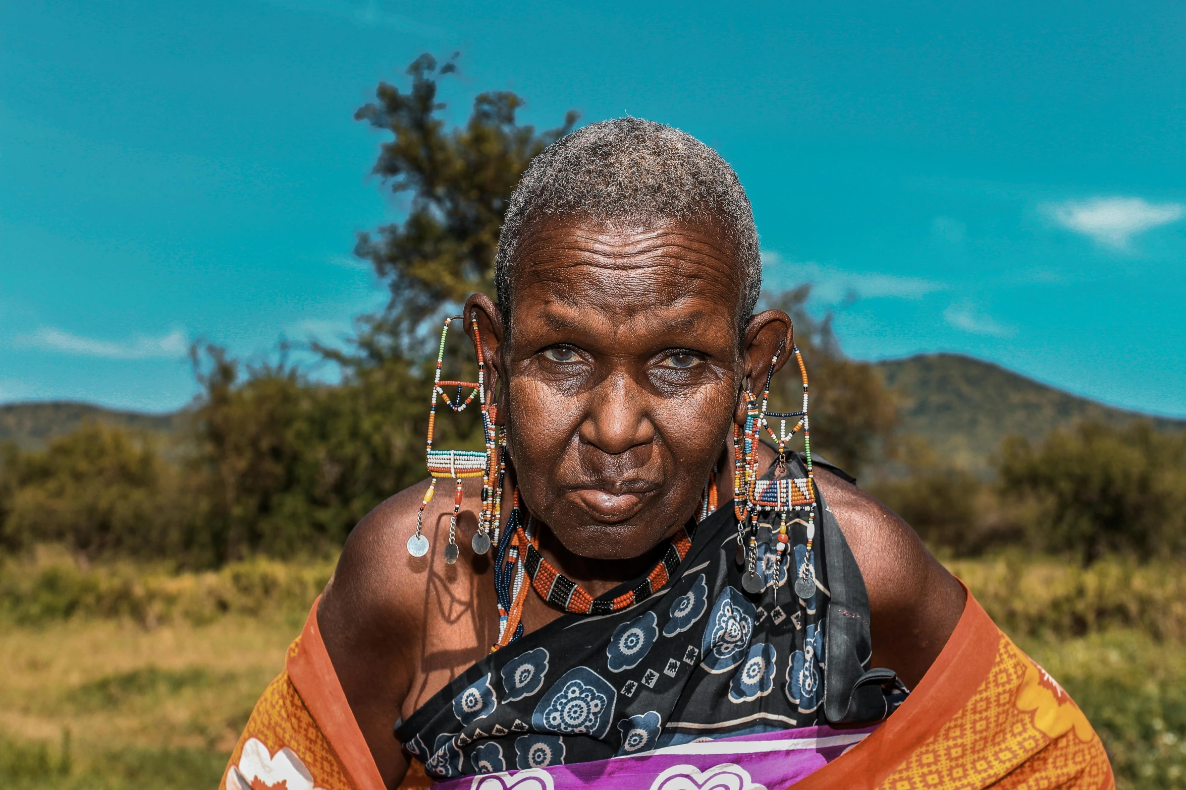 a woman with a face tattoo and two scarves on her head