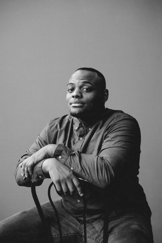 a man in a black and white image leaning on his chair