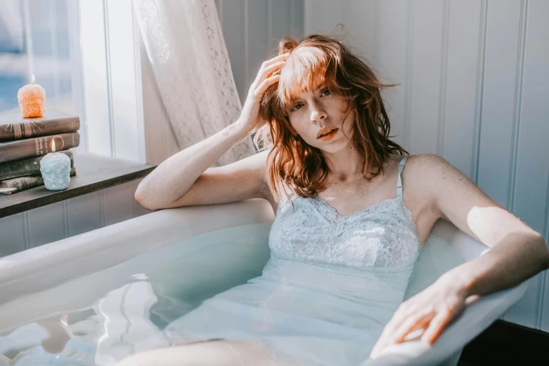 a woman that is sitting in a tub with water