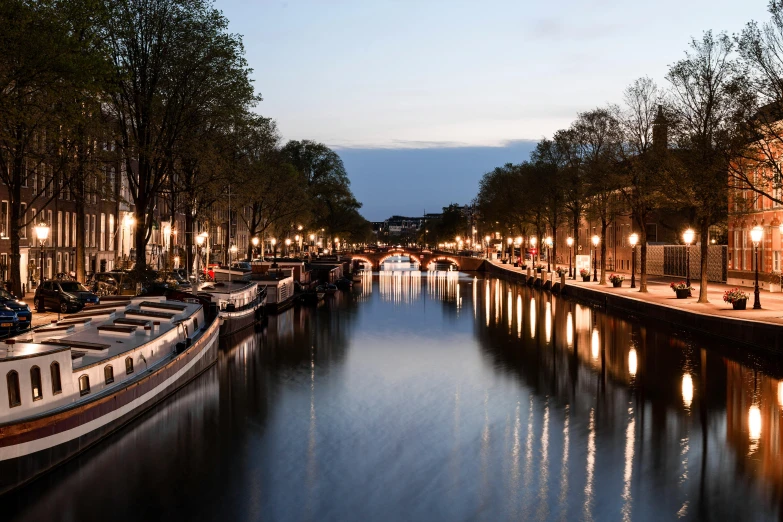 boats in the river between two buildings at night