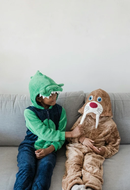 two young children dressed in costumes are sitting on a couch