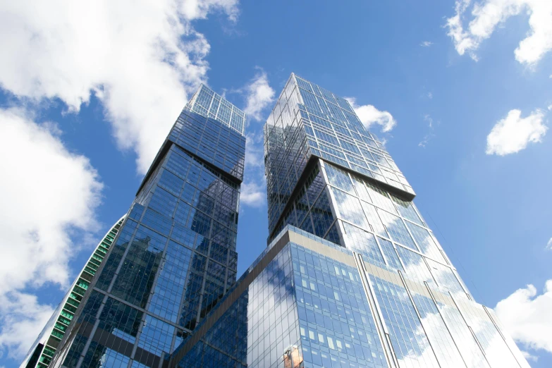 two tall buildings standing in front of a blue sky