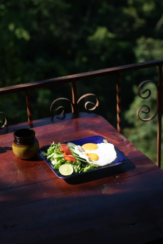 plate with egg and other food on top of wooden table