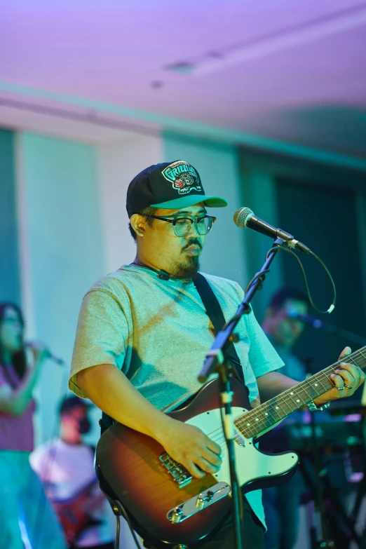 a man playing guitar with others behind him