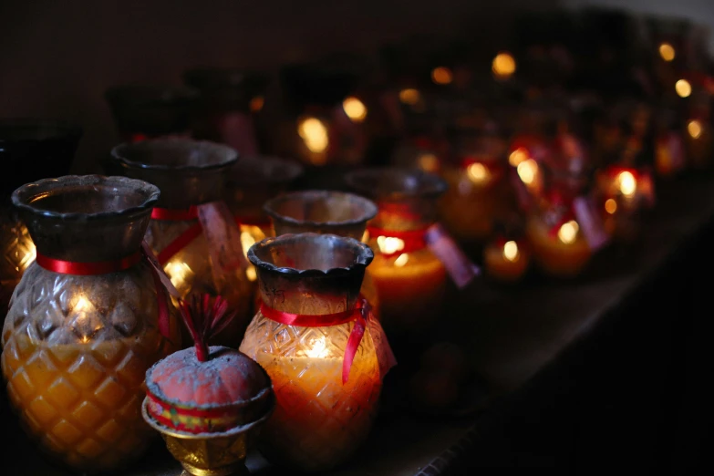 many lit candles sitting in rows in the dark