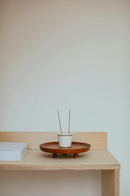 a white plate holding two needles in a bowl