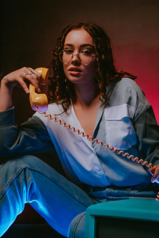 a woman sitting on a chair talking on a phone