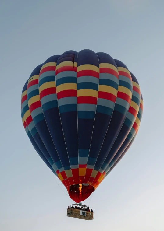 a balloon flying on the sky with a few people