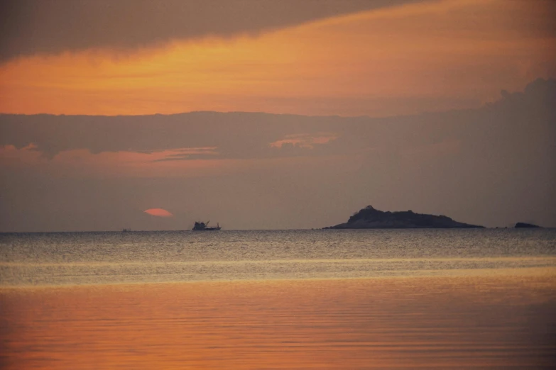 a boat out at sea in the sunset