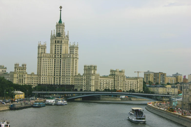 a large clock tower stands above a canal