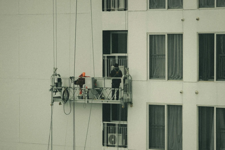 a man on a balcony near a building