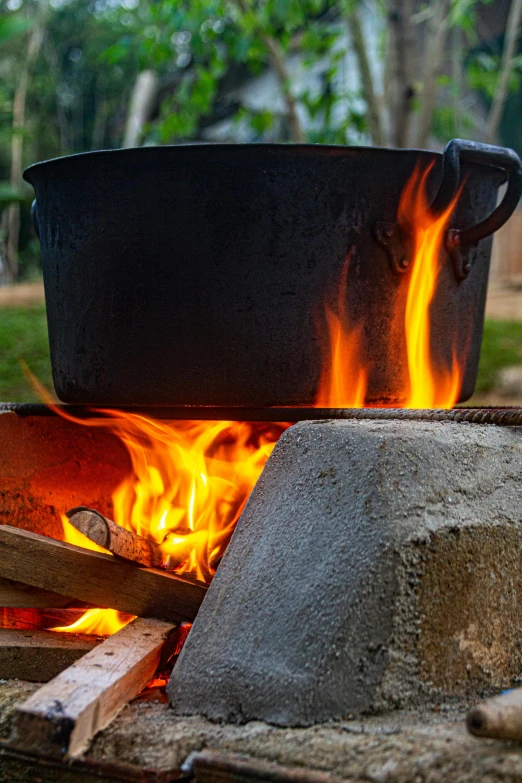 a bucket filled with liquid sitting next to a fire