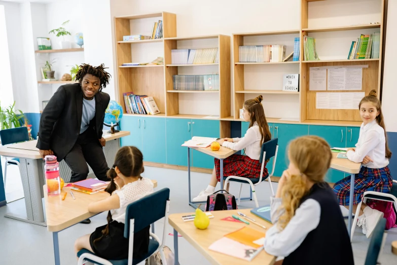 two students standing and talking in front of a classroom