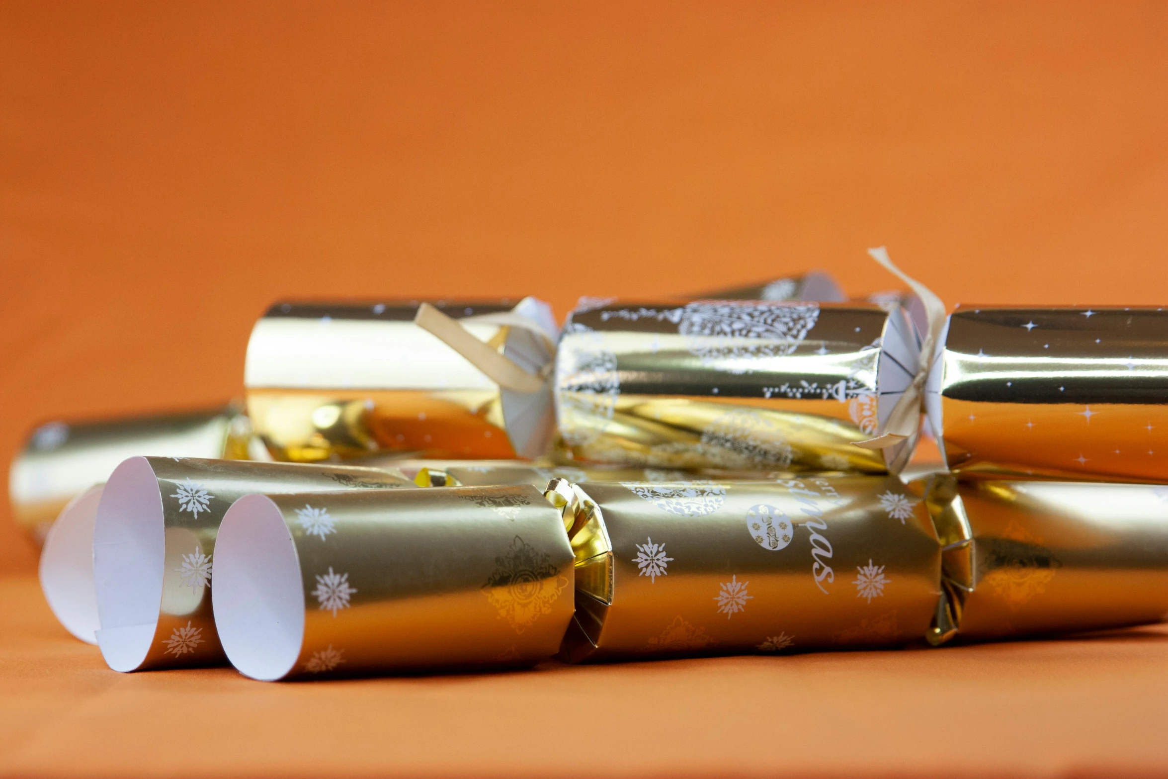 a set of four gold and white foil tube