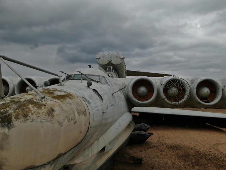 a wrecked airplane sits abandoned near some dirt