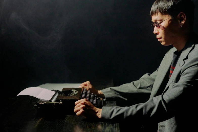 a man typing with an antique typewriter in front of him