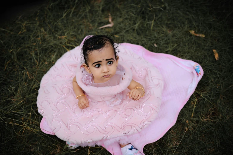 a baby doll sits in the grass