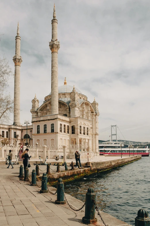 people walking by the water in front of buildings