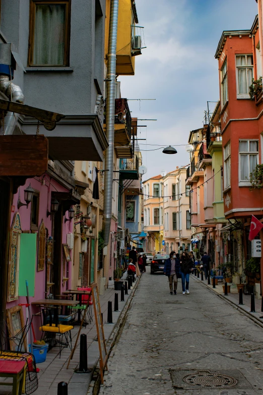 a narrow street is lined with colorful buildings