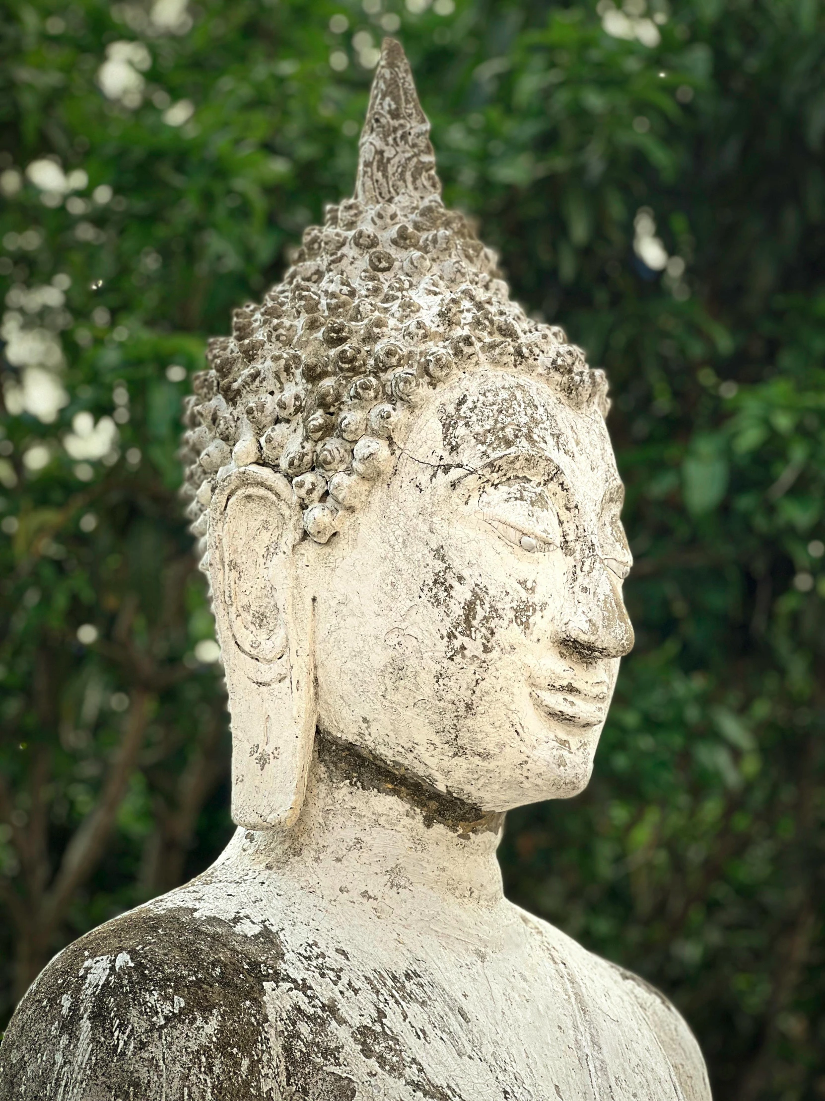 a stone statue is shown with trees in the background