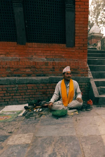 a man sitting on the ground next to some stairs