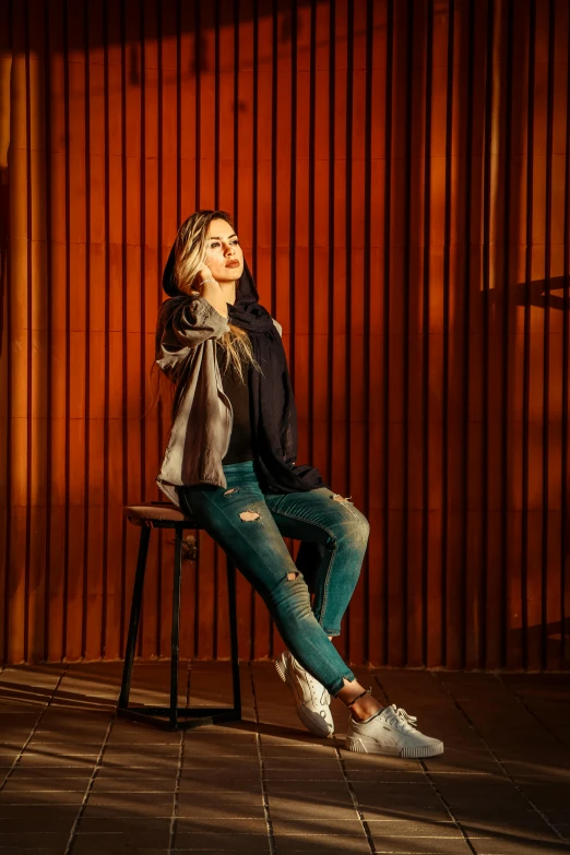 woman in jeans and black shirt sitting on chair looking up