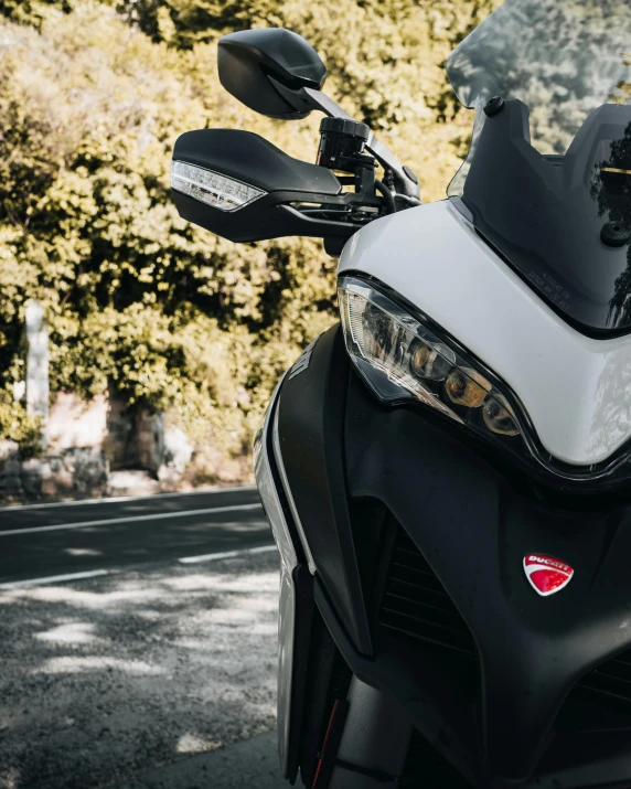 the front light of a motorbike sits on a city street