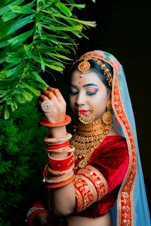 the bride is dressed in red and holds her hands up