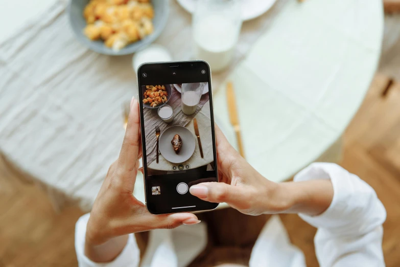 a woman holding her phone in front of her taking a picture