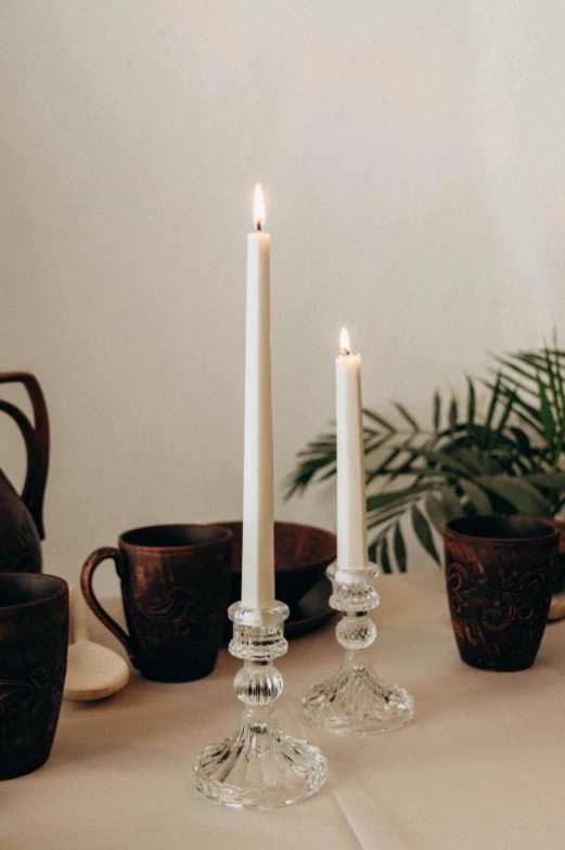 candles are set out on a table with cups