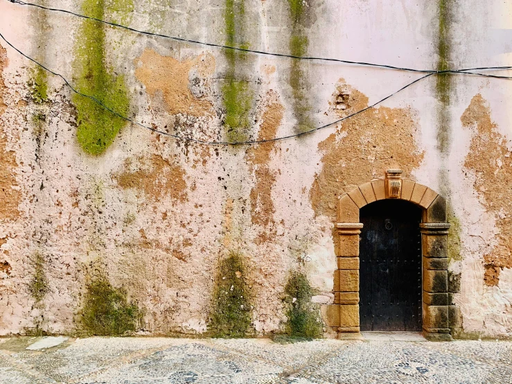 a door sits inside an old window on an abandoned building