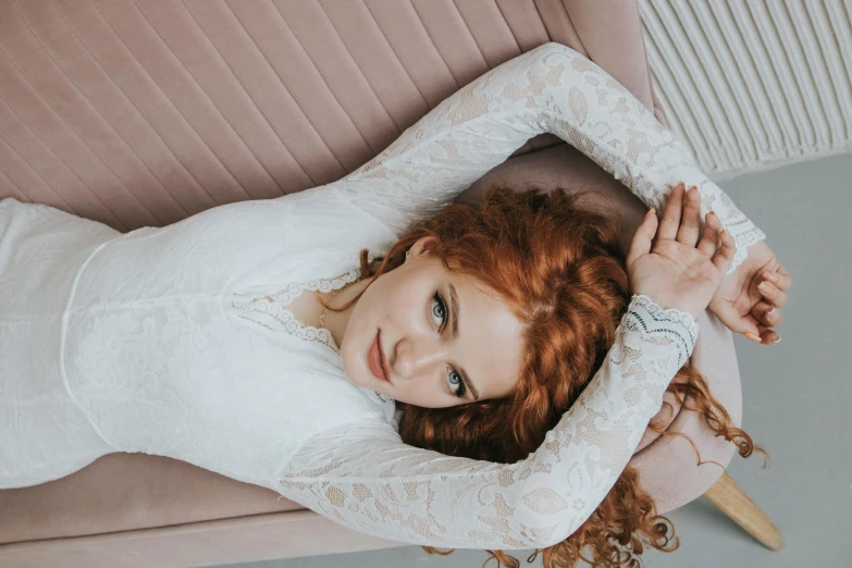 a red - haired girl with red hair is seated on the couch