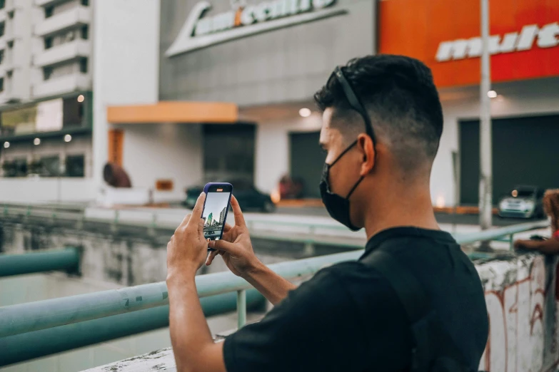 a man looking at his phone in front of an apple store