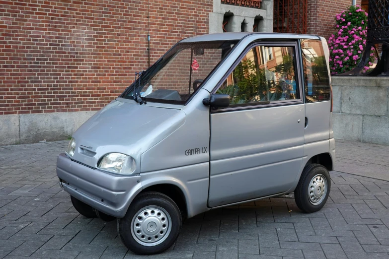 the silver van is parked on the brick side walk