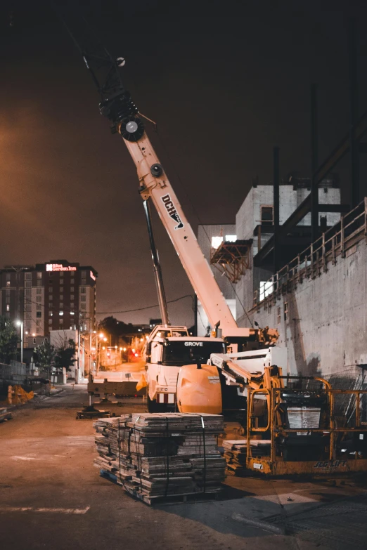 crane being lifted in parking lot at night time