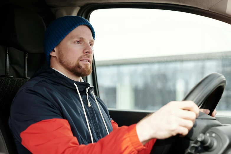 a man driving a car with a blue hat