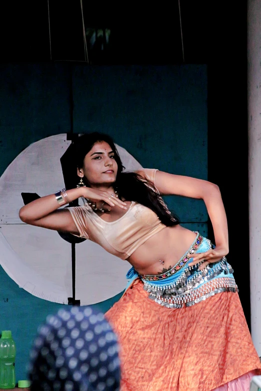 a woman in a skirt, with an umbrella on stage