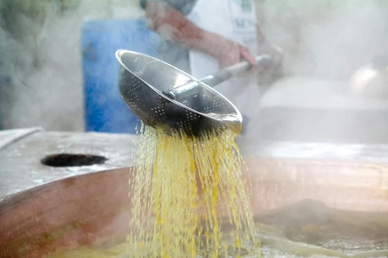 a person using a grater on some yellow liquid