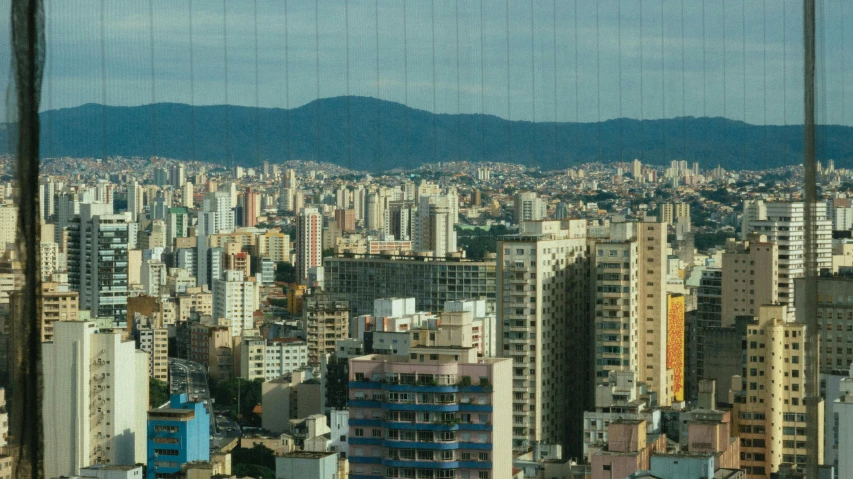 large city with skyscrs in the foreground, and mountains in the distance