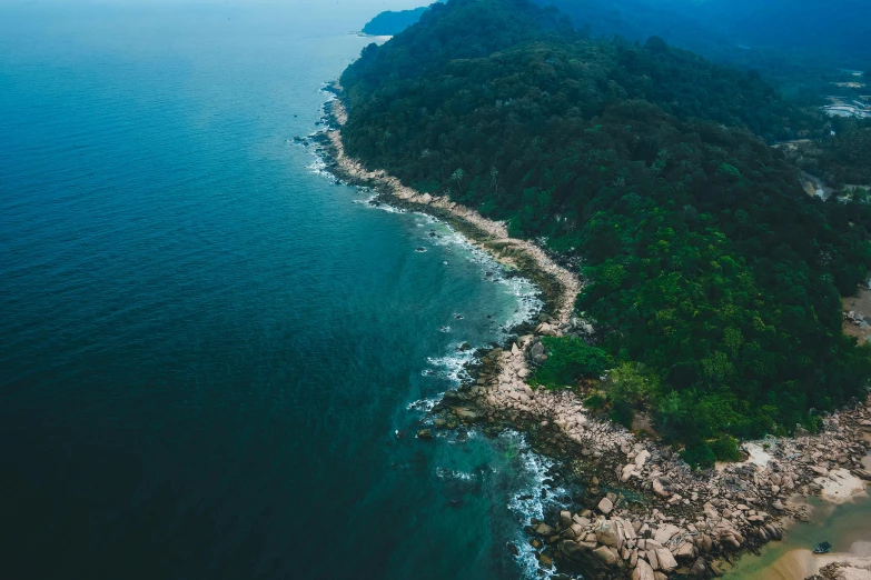 an aerial view of the shoreline and beach near a mountain