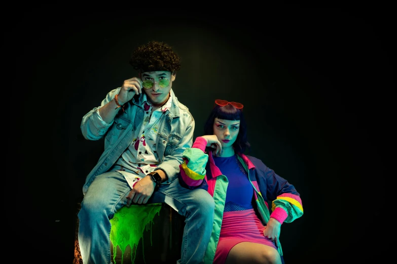 two people are sitting on green buckets with neon colors